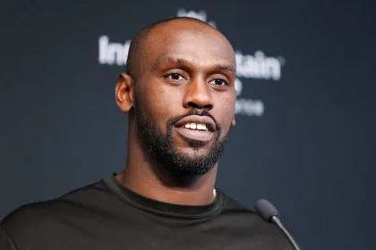 FootballR - NFL - Chandler Jones - Ein Mann in einem schwarzen Hemd steht bei der Pressekonferenz der Las Vegas Raiders vor einem Mikrofon.