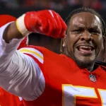 FootballR - NFL - Ein Footballspieler, Frank Clark, hält seine Faust hoch.