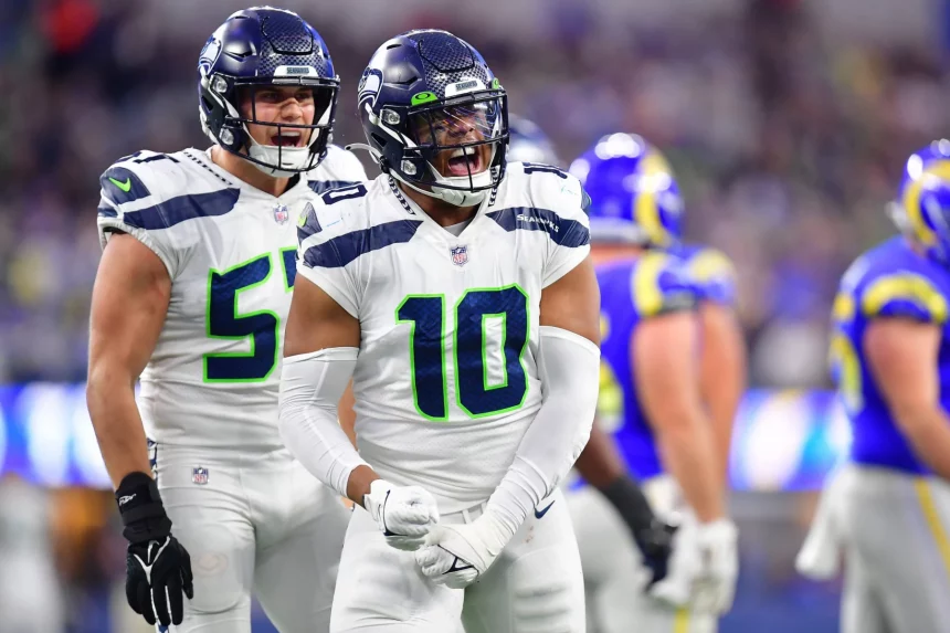 FootballR - NFL - Zwei Spieler der Seattle Seahawks auf dem Spielfeld, möglicherweise droht Edge Rusher Uchenna Nwosu eine Verletzung am Ende der Saison.