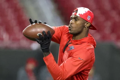 FootballR - NFL - Ein Mann mit rotem Hut wirft einen Football für die Eagles. Julio Jones