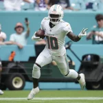 FootballR - NFL - Ein Spieler der Miami Dolphins, Tyreek Hill, der mit dem Ball läuft und die schnellste Offense in der NFL darstellt.