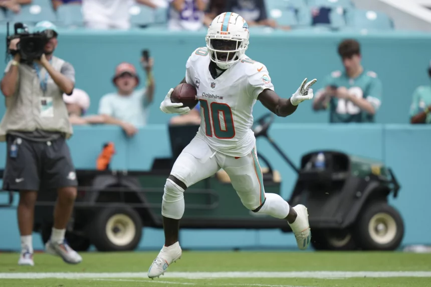 FootballR - NFL - Ein Spieler der Miami Dolphins, Tyreek Hill, der mit dem Ball läuft und die schnellste Offense in der NFL darstellt.