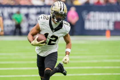 FootballR - NFL - Der Wide Receiver Chris Olave der New Orleans Saints spielt kraftvoll mit dem Ball.