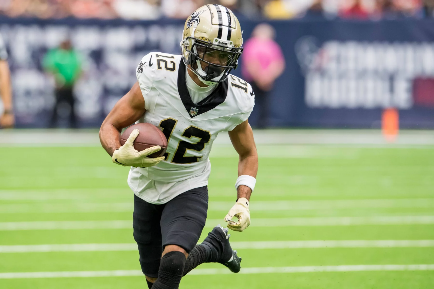 FootballR - NFL - Der Wide Receiver Chris Olave der New Orleans Saints spielt kraftvoll mit dem Ball.