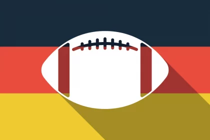 FootballR - NFL - Ein Football mit langem Schatten auf der Flagge Deutschlands bei den Frankfurt Games.