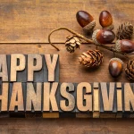 FootballR - NFL Thanksgiving 2025 - Das Wort Happy Thanksgiving auf einem Holztisch, umgeben von NFL Thanksgiving-Spiele und hochkarätigen Halftime Shows.