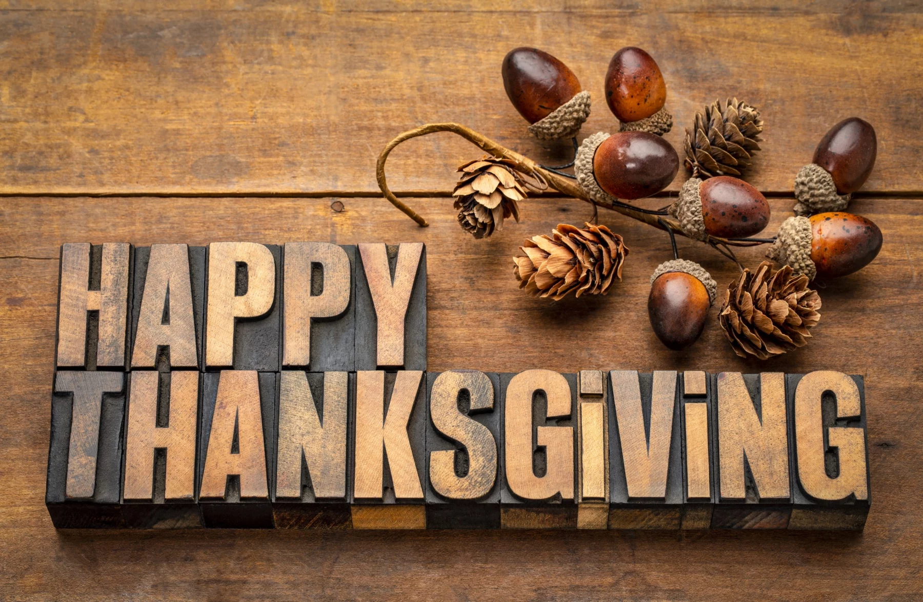 FootballR - NFL Thanksgiving 2025 - Das Wort Happy Thanksgiving auf einem Holztisch, umgeben von NFL Thanksgiving-Spiele und hochkarätigen Halftime Shows.