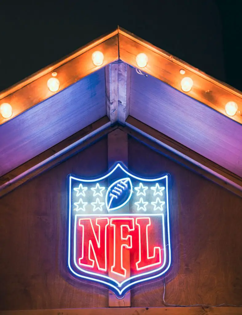 FootballR - NFL am Düsseldorfer Weihnachtsmarkt - Das NFL-Logo leuchtet während der Weihnachtszeit an der Seite eines Gebäudes.