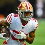 FootballR - NFL - Ein Footballspieler der San Francisco 49ers, der mit dem Ball läuft, George Odum.