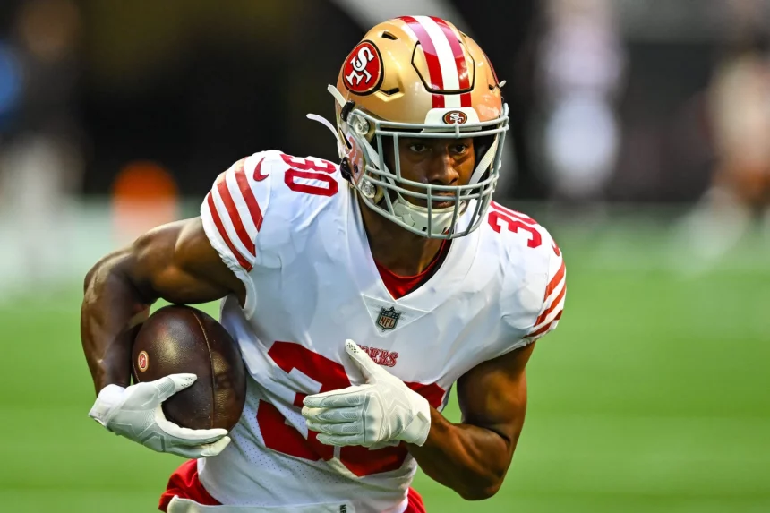 FootballR - NFL - Ein Footballspieler der San Francisco 49ers, der mit dem Ball läuft, George Odum.