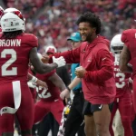 FootballR - NFL - Spieler der Arizona Cardinals schütteln während eines Spiels einem optimistischen Kyler Murray die Hand.
