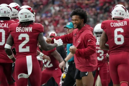 FootballR - NFL - Spieler der Arizona Cardinals schütteln während eines Spiels einem optimistischen Kyler Murray die Hand.