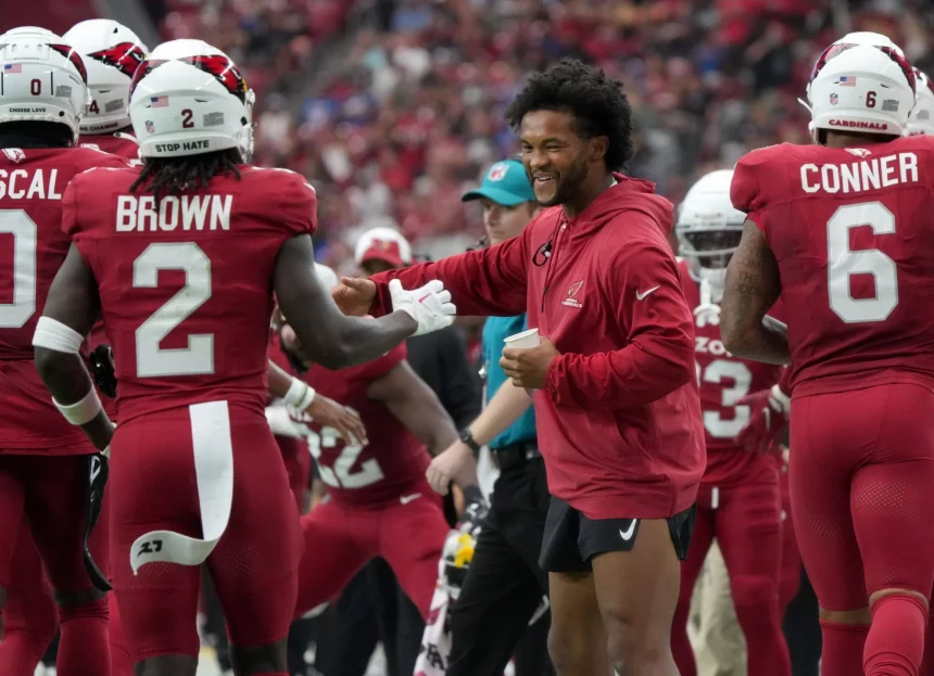 FootballR - NFL - Spieler der Arizona Cardinals schütteln während eines Spiels einem optimistischen Kyler Murray die Hand.