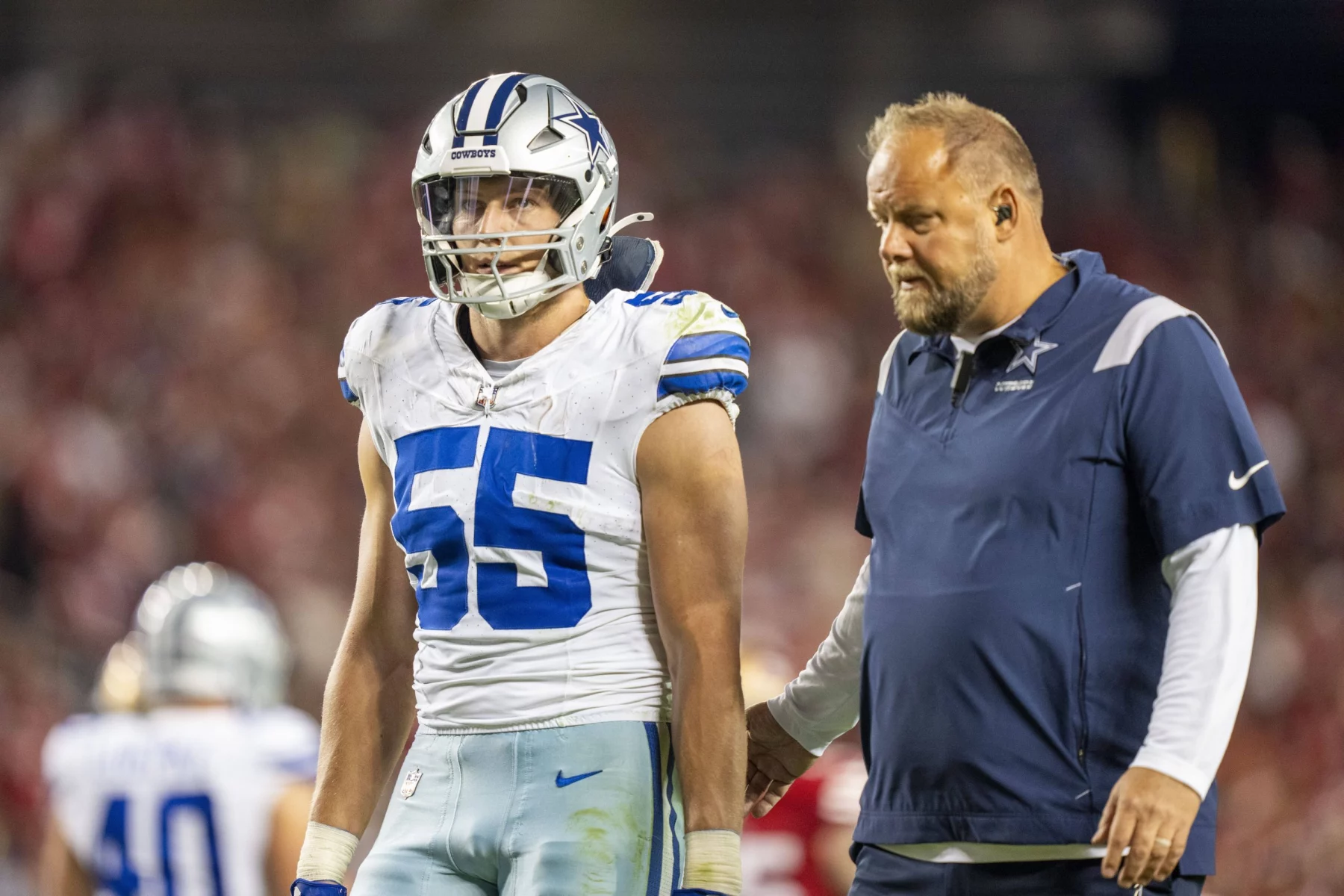 FootballR - NFL - Dallas Cowboys Assistant, spricht mit einem Spieler auf dem Spielfeld namens Leighton Vander Esch.
