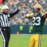 FootballR - NFL - Ein Footballspieler der Green Bay Packers, Running Back Aaron Jones, zeigt beim Spiel gegen die Detroit Lions auf den Schiedsrichter.