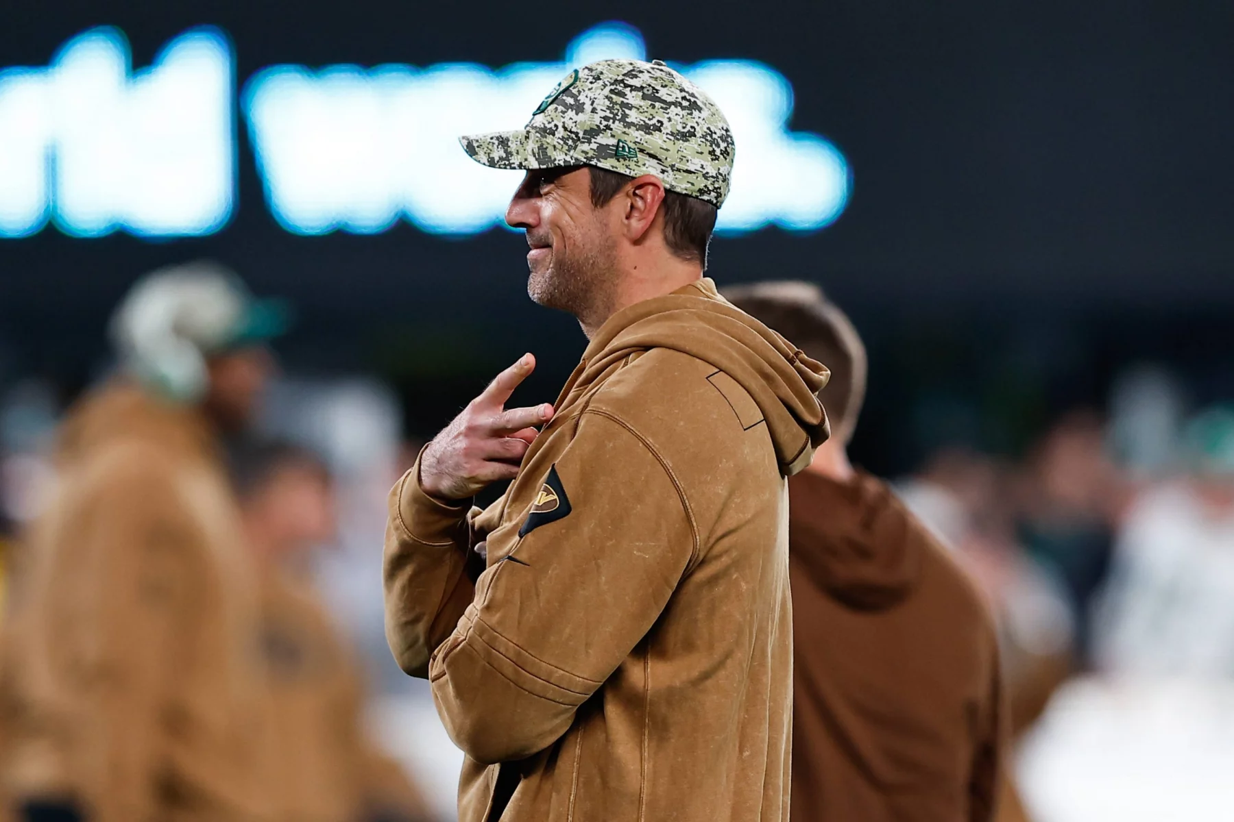 FootballR - NFL - Ein Footballspieler der New York Jets (aaron Rodgers) , der sich kürzlich eine Achillessehnenverletzung zugezogen hat, steht am Spielfeldrand und wartet sehnsüchtig auf seine Rückkehr ins Spiel.