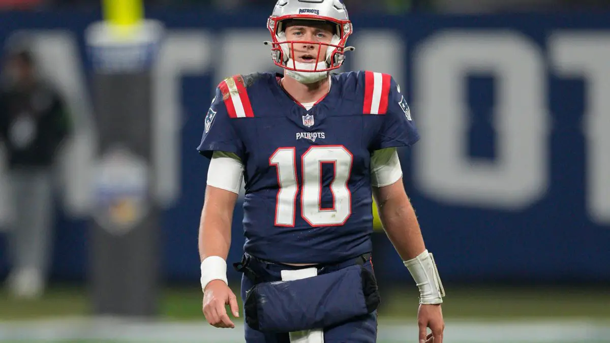 FootballR - NFL - Der Starting-Quarterback der New England Patriots, Mac Jones, läuft über das Spielfeld.