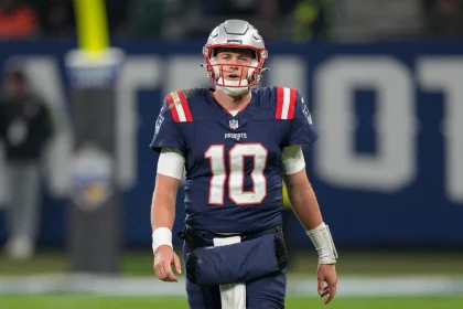 FootballR - NFL - Der Starting-Quarterback der New England Patriots, Mac Jones, läuft über das Spielfeld.