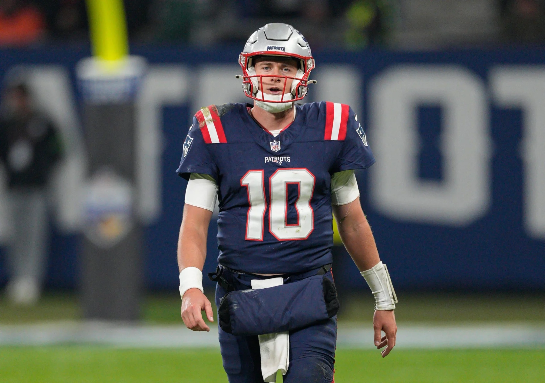 FootballR - NFL - Der Starting-Quarterback der New England Patriots, Mac Jones, läuft über das Spielfeld.