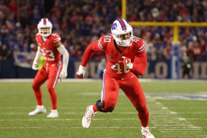 FootballR - NFL - Ein Bills-Footballspieler läuft neben Bills-Star Von Miller auf dem Spielfeld.