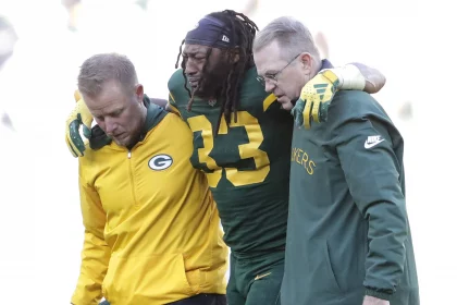 FootballR - NFL - Packers RB Aaron Jones wird nach einem Spiel gegen die Chargers vom Feld geholfen.