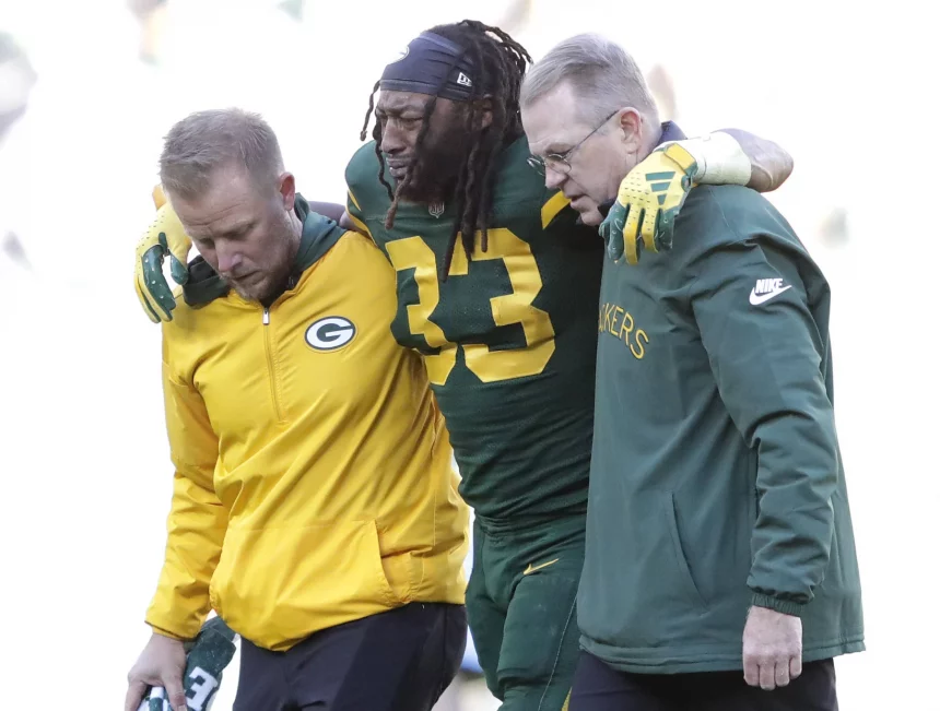 FootballR - NFL - Packers RB Aaron Jones wird nach einem Spiel gegen die Chargers vom Feld geholfen.