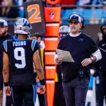 FootballR - NFL - Der Cheftrainer der Panthers, Frank Reich, spricht mit seinen Spielern auf dem Feld.