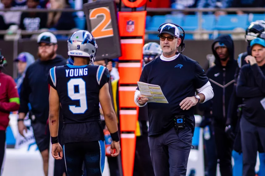 FootballR - NFL - Der Cheftrainer der Panthers, Frank Reich, spricht mit seinen Spielern auf dem Feld.