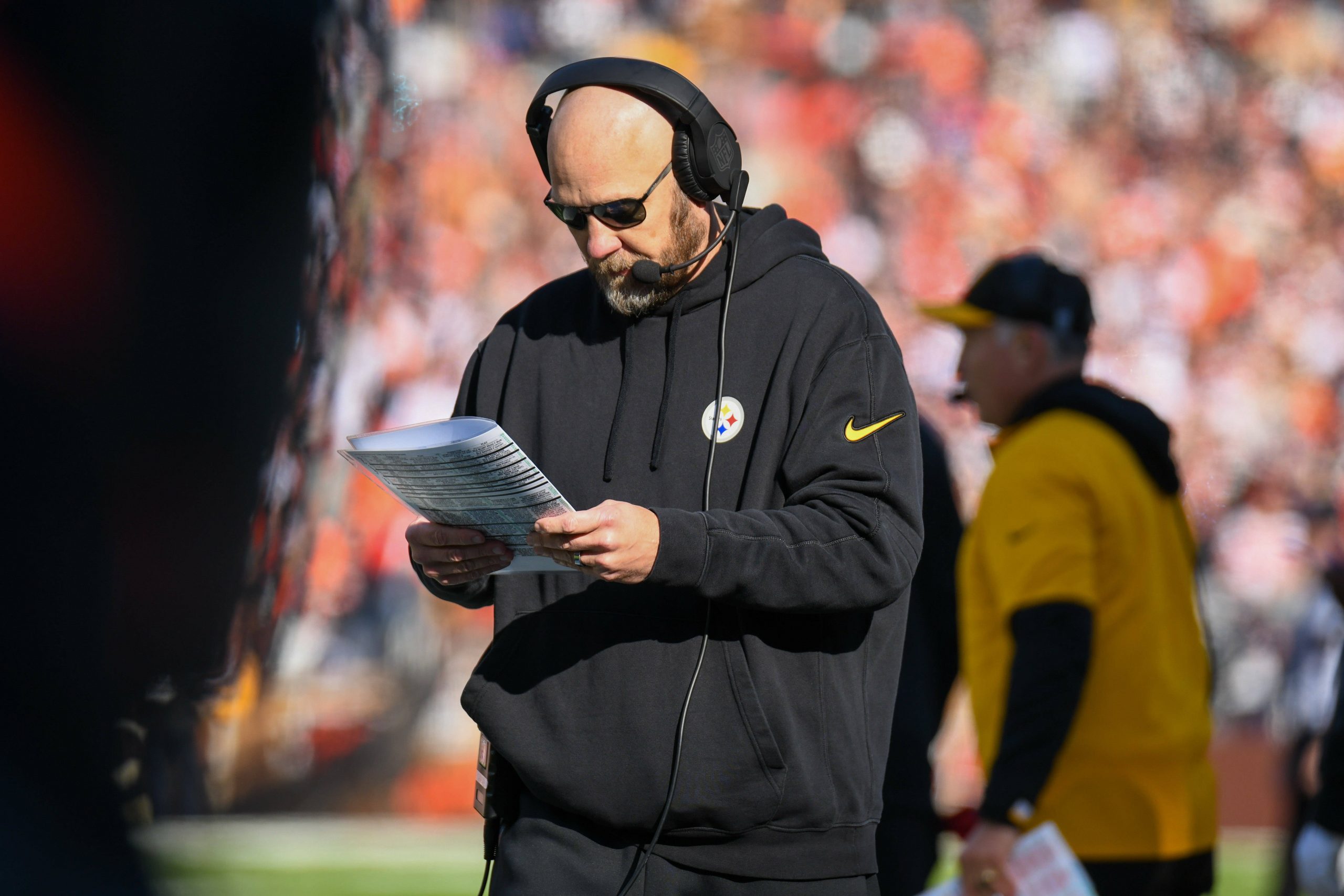 FootballR - NFL - Der Offensivkoordinator der Pittsburgh Steelers, Matt Canada, liest am Spielfeldrand eine Zeitung.