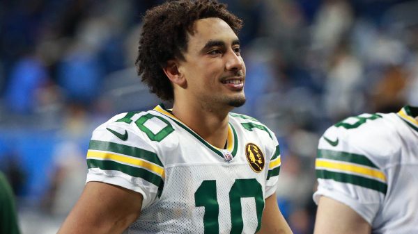 FootballR - NFL - Zwei Packers-Spieler, Jordan Love und ein Teamkollege, lächeln nach Spielende.