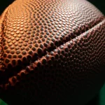 FootballR - NFL Teams - Eine Nahaufnahme eines Footballs auf dunklem Hintergrund mit NFL-Teams.
