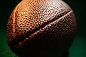 NFL Preseason - NFL Teams - Eine Nahaufnahme eines Footballs auf dunklem Hintergrund mit NFL-Teams.