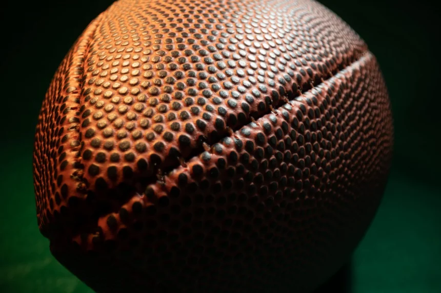 FootballR - NFL Teams - Eine Nahaufnahme eines Footballs auf dunklem Hintergrund mit NFL-Teams.