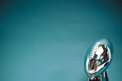 FootballR - NFL - Eine Footballtrophäe auf blauem Hintergrund, perfekt für Footballfans.