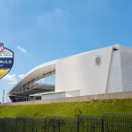 FootballR - NFL - Ein weißes Gebäude mit einem Logo davor. Corinthians Arena Sao Paulo - NFL Brasilien