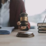 FootballR - NFL - Eine Frau hält einen Richterhammer auf einem Schreibtisch und leitet den Mordfall der Mutter eines Ex-NFL-Spielers, Sergio Brown, während sie „nicht schuldig“ erklärt.