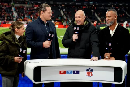 FootballR - RTL NFL - Eine Gruppe von Menschen steht vor einem NFL-Footballfeld.