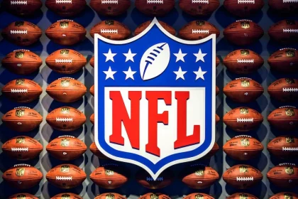 FootballR - NFL - NFL-Logo auf einer Wand aus Bällen.