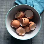 FootballR - NFL - Zerbrochene Eier in einer Schüssel auf einem Holztisch.