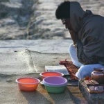 FootballR - NFL - Ein Mann sitzt auf dem Boden neben einer Schüssel mit Essen.