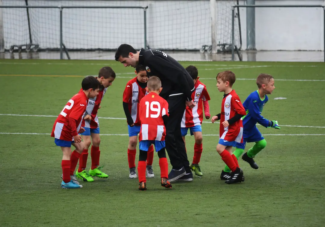 FootballR - NFL - Eine Gruppe Kinder spielt Fußball auf einem Feld.