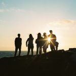 FootballR - NFL - Eine Gruppe von Menschen steht auf einer Klippe mit Blick auf den Ozean.
