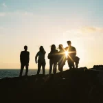 FootballR - NFL - Eine Gruppe von Menschen steht auf einer Klippe mit Blick auf den Ozean.