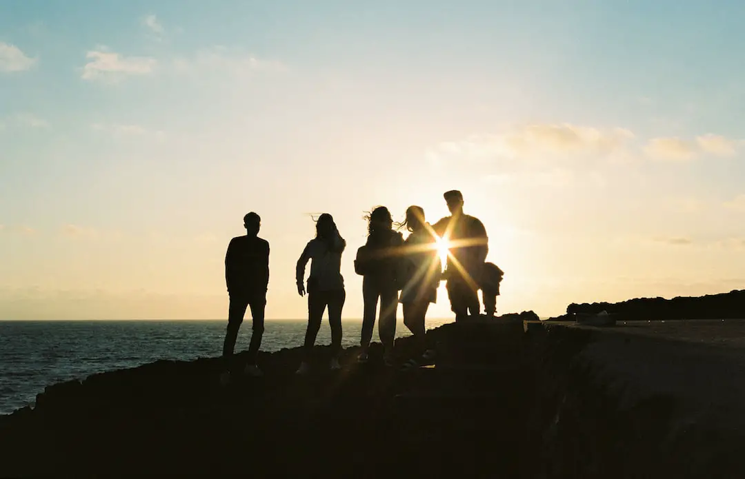 FootballR - NFL - Eine Gruppe von Menschen steht auf einer Klippe mit Blick auf den Ozean.