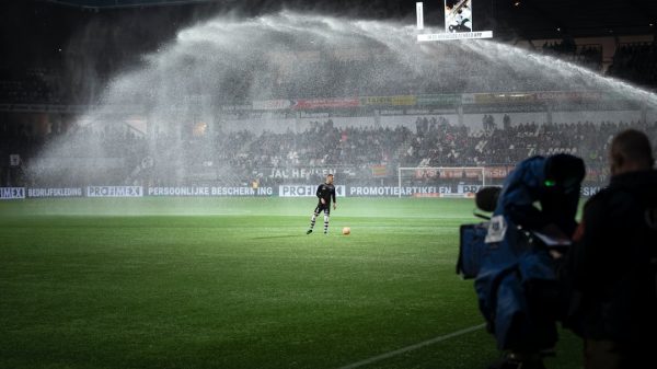 FootballR - NFL - Ein Fußballspieler wird auf einem Fußballfeld mit Wasser besprüht.