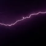 FootballR - NFL - Am dunklen Himmel ist ein violetter Blitz zu sehen.