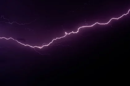 FootballR - NFL - Am dunklen Himmel ist ein violetter Blitz zu sehen.