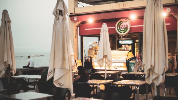FootballR - NFL - Ein Restaurant mit Tischen und Sonnenschirmen direkt am Meer.