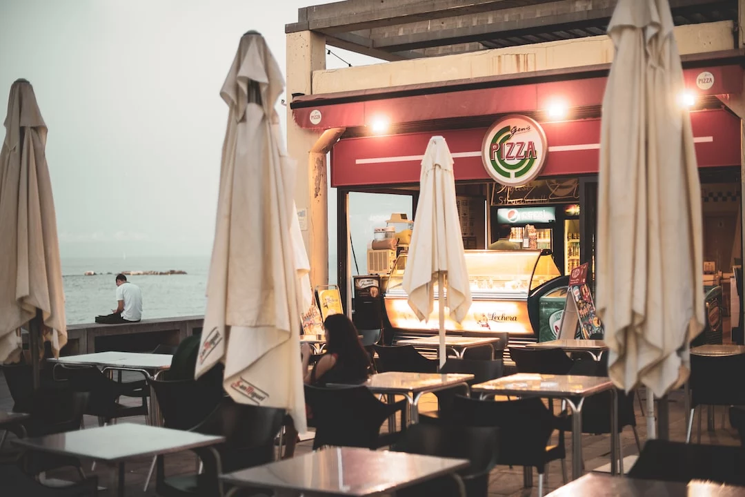 FootballR - NFL - Ein Restaurant mit Tischen und Sonnenschirmen direkt am Meer.