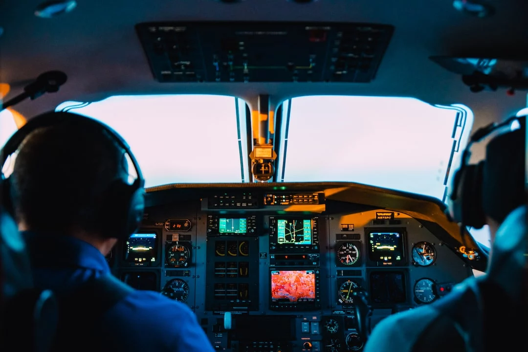 FootballR - NFL - Zwei Personen sitzen im Cockpit eines Flugzeugs.